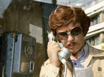 Жорж Милославский в телефонной будке разговаривает по телефону.